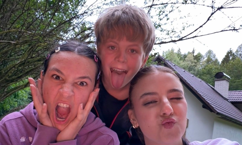 Tři táborníci dělají legrační obličeje do selfie